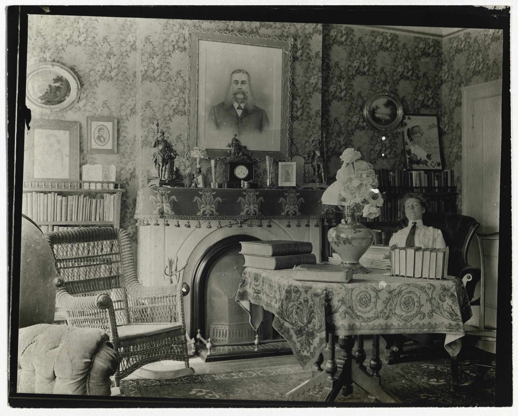 a black-and-white photo from the late 19th century of a woman seated in an ornate Victorian parlor