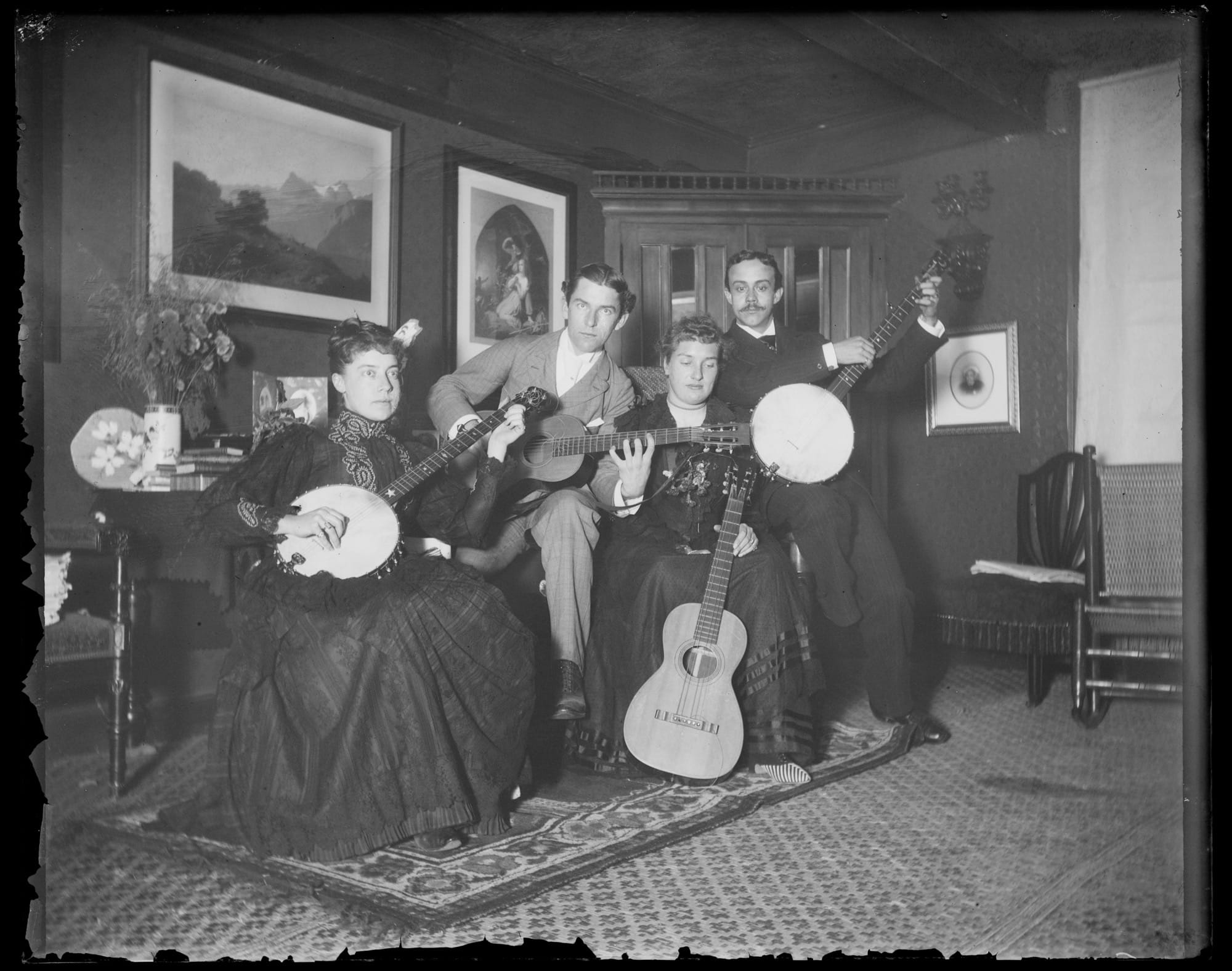 a black-and-white photo from the late 19th century of a large group of people during a playful tea party