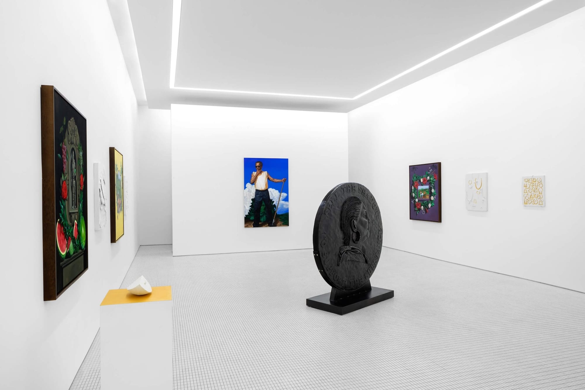 an installation view of paintings and sculptures in a gallery