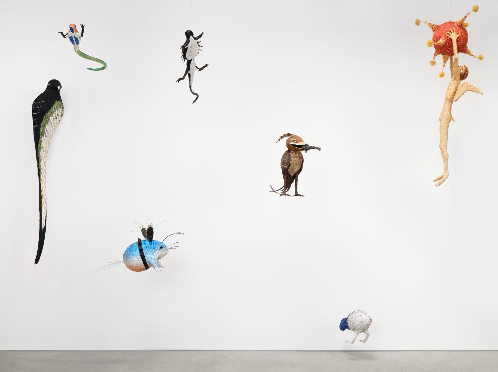 an installation view of numerous paper sculptures by Roberto Benavidez on a gallery wall